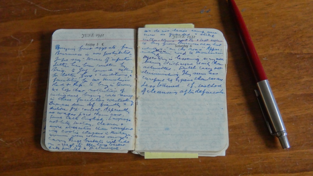 Small handwritten 1943 diary open beside a red pen